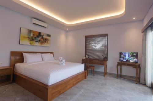 ein Schlafzimmer mit einem Bett und einem Fernseher in der Unterkunft Villa Diva in Ketewel