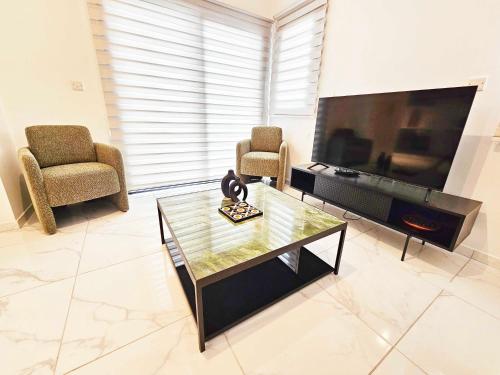 a living room with a large television and two chairs at Alexander Residence Trikallon Str in Nicosia