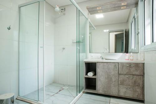 un bagno con doccia in vetro e lavandino di Casa ampla e confortável a Lajeado