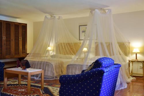 a bedroom with a bed with mosquito nets at Pestana Miramar São Tomé in São Tomé