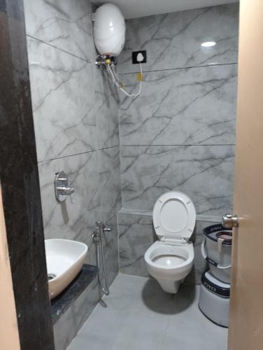 a bathroom with a toilet and a sink at Hotel Palliate Inn in Ahmedabad