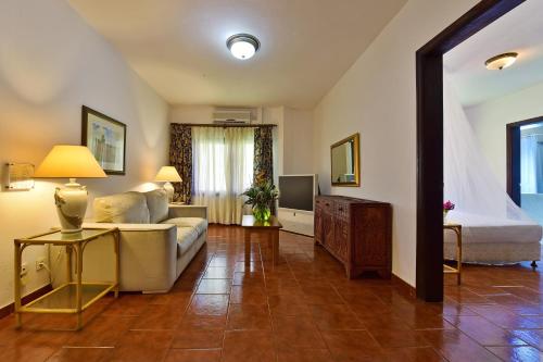 a living room with a couch and a bed at Pestana Miramar São Tomé in São Tomé