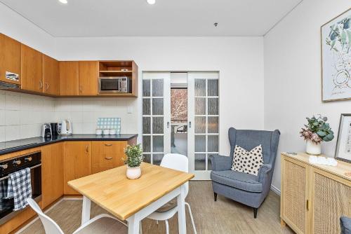 a kitchen with a table and a chair in a room at A city oasis - full apartment with balcony in Perth