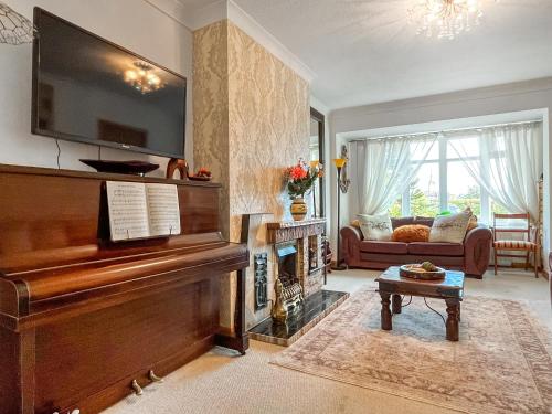a living room with a piano and a couch at Roselynne in Redcar