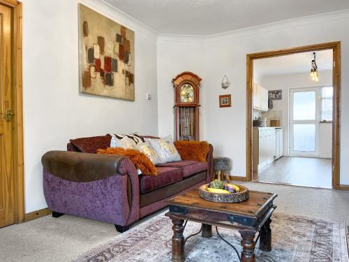 a living room with a purple couch and a table at Roselynne in Redcar