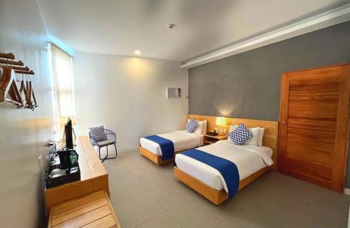 a hotel room with two beds and a desk at Bay's Inn Resort in Baler