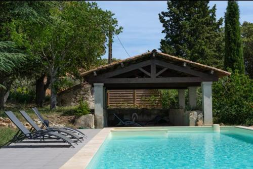 a swimming pool with chairs and a gazebo at Joli 2 pièces dans maison au calme absolu in Saint-Julien