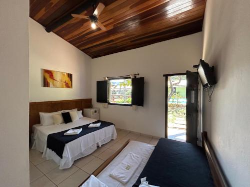 a bedroom with two beds and a ceiling fan at Pousada Anauê Cipó in Serra do Cipo