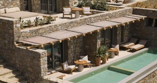 a building with a swimming pool next to a house at Collini Hotel Mykonos, WorldHotels Elite in Fanari