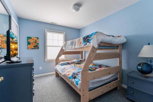 a bedroom with a bunk bed and blue walls at 235 E Spicer Ave, Unit A in Wildwood