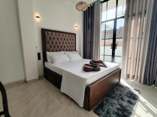 a bedroom with a large bed and a large window at One Love in Weligama