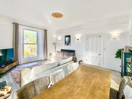 een woonkamer met een bank en een tv bij Cedars in Mortehoe