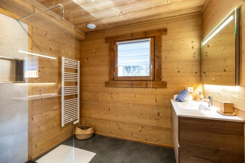 Chalet Serra Del Cadi - Vue montagne في فون-رومو-أوديللو-فيا: حمام بجدران خشبية ومغسلة ونافذة