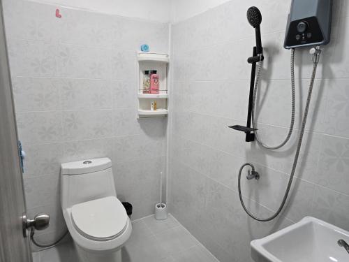 a bathroom with a shower with a toilet and a sink at บ้านสุขใจ Baan Sukjai in Surat Thani