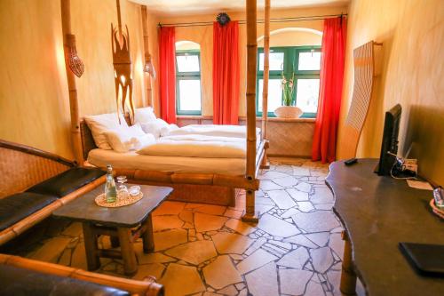 ein Schlafzimmer mit Bett, Sofa und Fernseher in der Unterkunft Backstage Hotel in Dresden