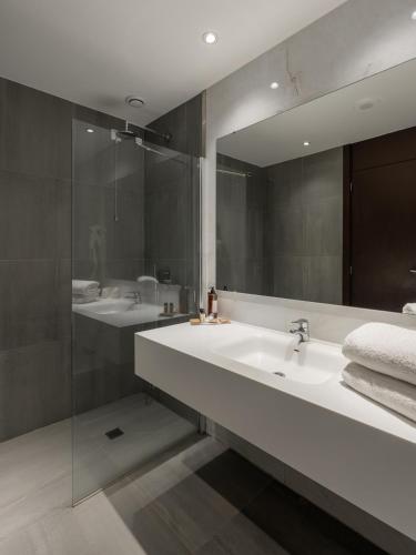 a bathroom with two sinks and a large mirror at Hotel Premium Porto Maia in Maia