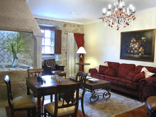 a living room with a red couch and a table at Pazo a Capitana in Cambados