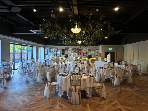 un salón de banquetes con mesas y sillas y una lámpara de araña en Holiday Inn Newcastle Gosforth Park by IHG, en Newcastle