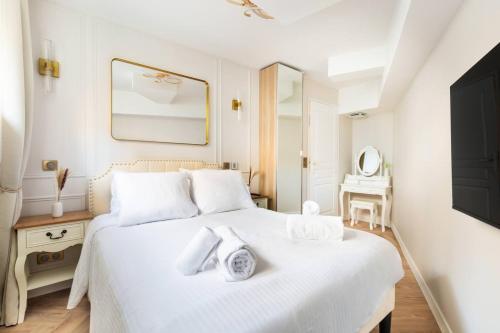 Sublime 3 chambres a Montmartre avec Clim et Jacuzzi في باريس: غرفة نوم بيضاء مع سرير أبيض ومرآة