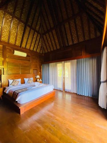 a bedroom with a large bed in a room at Chaplet House 2 in Ubud