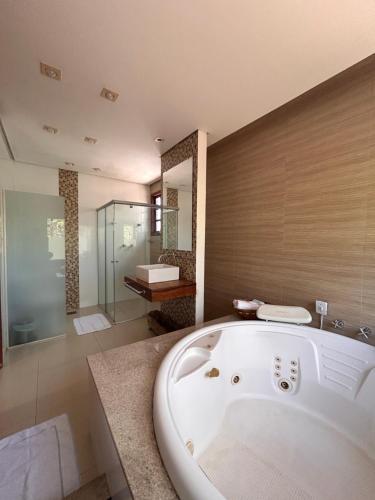 a large bathroom with a tub and a shower at Pousada Recanto da Serra in Serra do Cipo