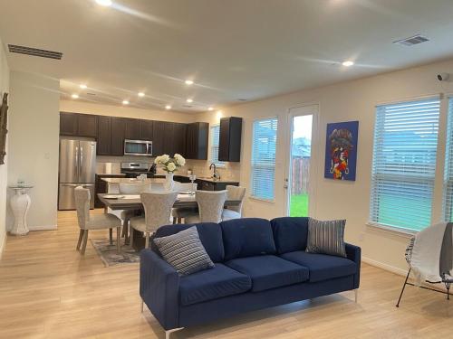 a living room with a blue couch and a kitchen at Vees home away from home in Rosharon