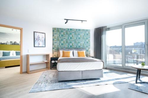 een slaapkamer met een bed en een groot raam bij HOTEL Am Spichernplatz in Düsseldorf
