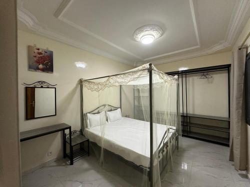 a bedroom with a canopy bed and a mirror at Express at home in Dakar