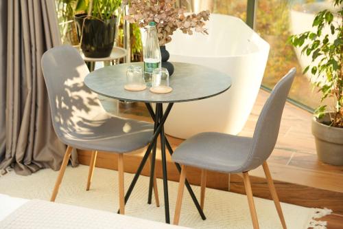 a table with two chairs and a vase on it at Moonlight Apartments Tirana in Tirana