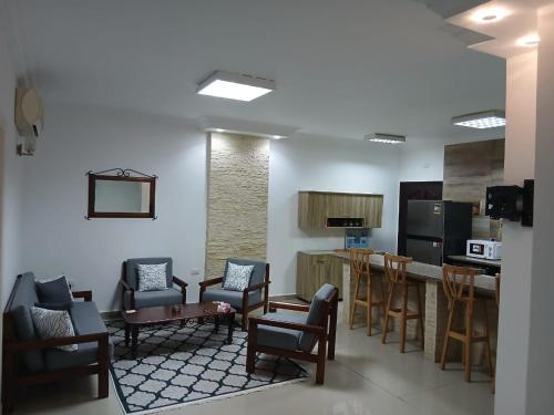 a living room with chairs and a kitchen with a counter at Sea View 2 Bedroom Apartment in El-Hadaba in Hurghada