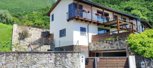 a house with a balcony and a stone wall at Villa Raggio di Sole in Abbadia Lariana