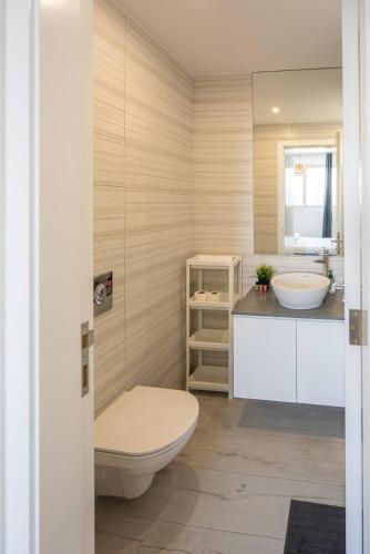 a bathroom with a toilet and a sink and a mirror at Hubstay Tamara Gardens 2 Bed Apt Suite with Pool in Livadhia