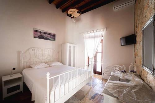a bedroom with a white bed and a window at Villa To Palati with Private Pool Anogyra in Anoyira