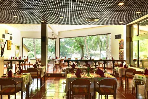 a dining room with tables and chairs and people at Pestana Miramar São Tomé in São Tomé