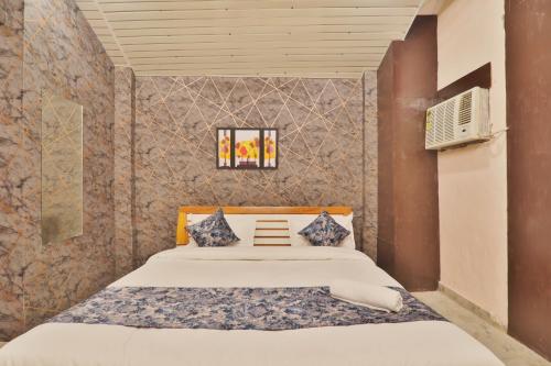 een slaapkamer met een bed en een tv aan de muur bij Hotel Kasol Heritage in Lucknow