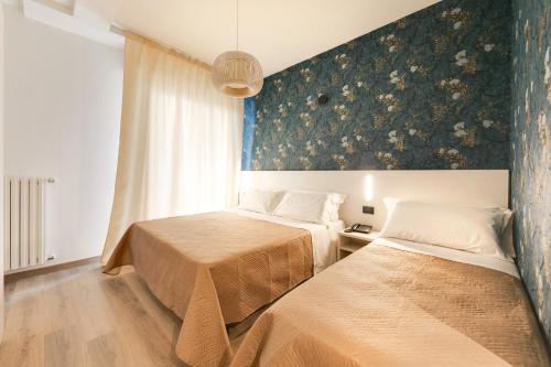 ein Schlafzimmer mit zwei Betten und einem Wandbild in der Unterkunft Executive Hotel Evolution - Spiaggia Inclusa in Cesenatico