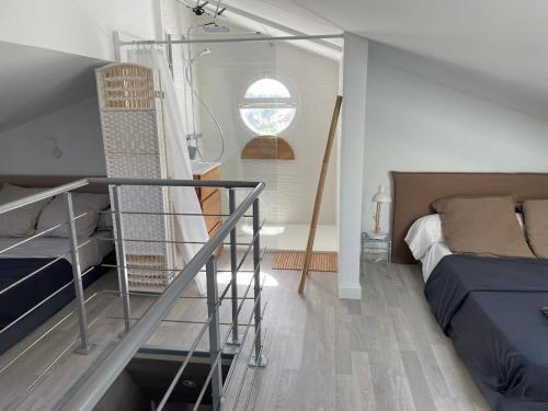 a bedroom with a bed and a staircase with a window at L 'Évasion in Saint-Cyprien