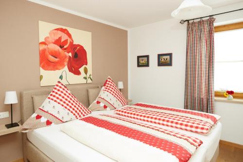オーベルストドルフにある"Alpenliebe"のベッドルーム1室(赤と白の枕が備わるベッド1台付)