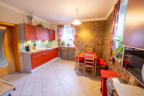 eine Küche mit roten Schränken und ein Tisch mit einem roten Tisch in der Unterkunft Apartmenthaus 113 in Stadl an der Mur