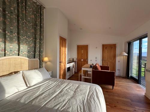 a bedroom with a bed and a table and a desk at Speuran Mora in Saasaig