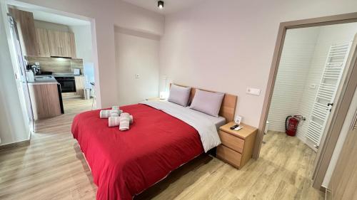 a bedroom with a large red bed with two candles on it at Karanasiou Apartment in Tríkala