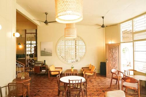 Un restaurante con mesas y sillas y una lámpara de araña. en Lewis house sweet, en San Juan