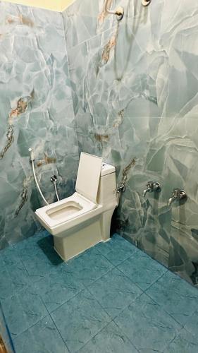 une salle de bain avec des toilettes et un lavabo dans l'établissement Maruthi Comforts, à Bangalore