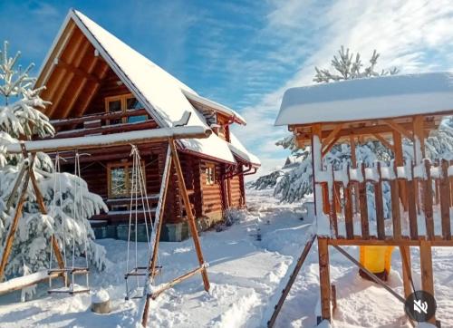 a log cabin in the snow with a gazebo at VILA LENA in Kokin Brod