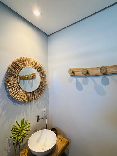 a bathroom with a toilet and a mirror on the wall at Jaguarype Bangalôs in Fortim