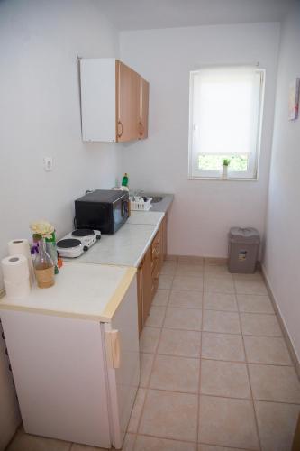 a small kitchen with a counter and a window at Unit Stay Mostar in Mostar
