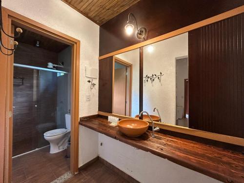 a bathroom with a wooden sink and a toilet at Pousada Meraki in Serra do Cipo