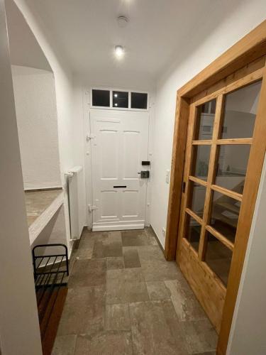 a hallway with a white door and a chair at S & C Ferienhaus in Oberbettingen