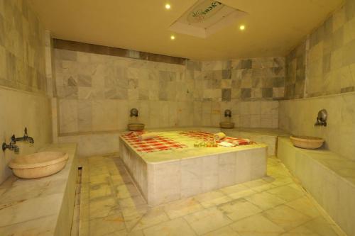 a large bathroom with a tub and a bed in it at Lycus River Thermal Hotel in Pamukkale