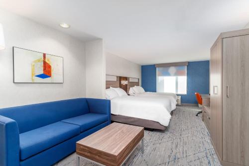 a hotel room with a bed and a blue couch at Holiday Inn Express Hotel Twin Falls by IHG in Twin Falls